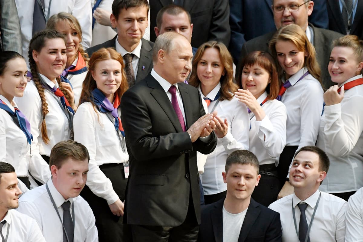 Vladimir Putin tervehtii Suora linja -ohjelman vapaaehtoisia puhelinpäivystäjiä Moskovassa.