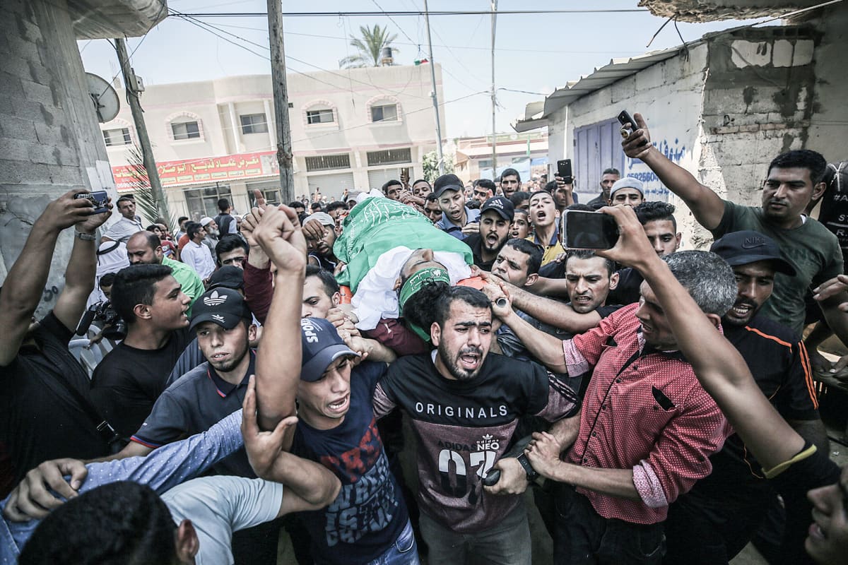 Palestiinalaiset kantavat 23-vuotiaan Ahmad Al-Qarran ruumista hänen hautajaisissaan Khan Younisissa, Gazassa 27. heinäkuuta.