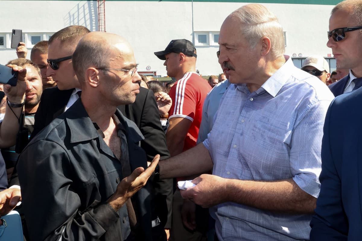 Valko-Venäjän presidentti Alexander Lukashenko keskustelee tehtaan työtekijän kanssa. Lukashenko piti puheen rengastehtaalla 17. elokuuta.