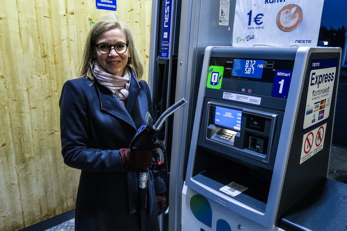 Katri Taskinen uusituvan dieselpumpun tankkauspistooli kädessä.