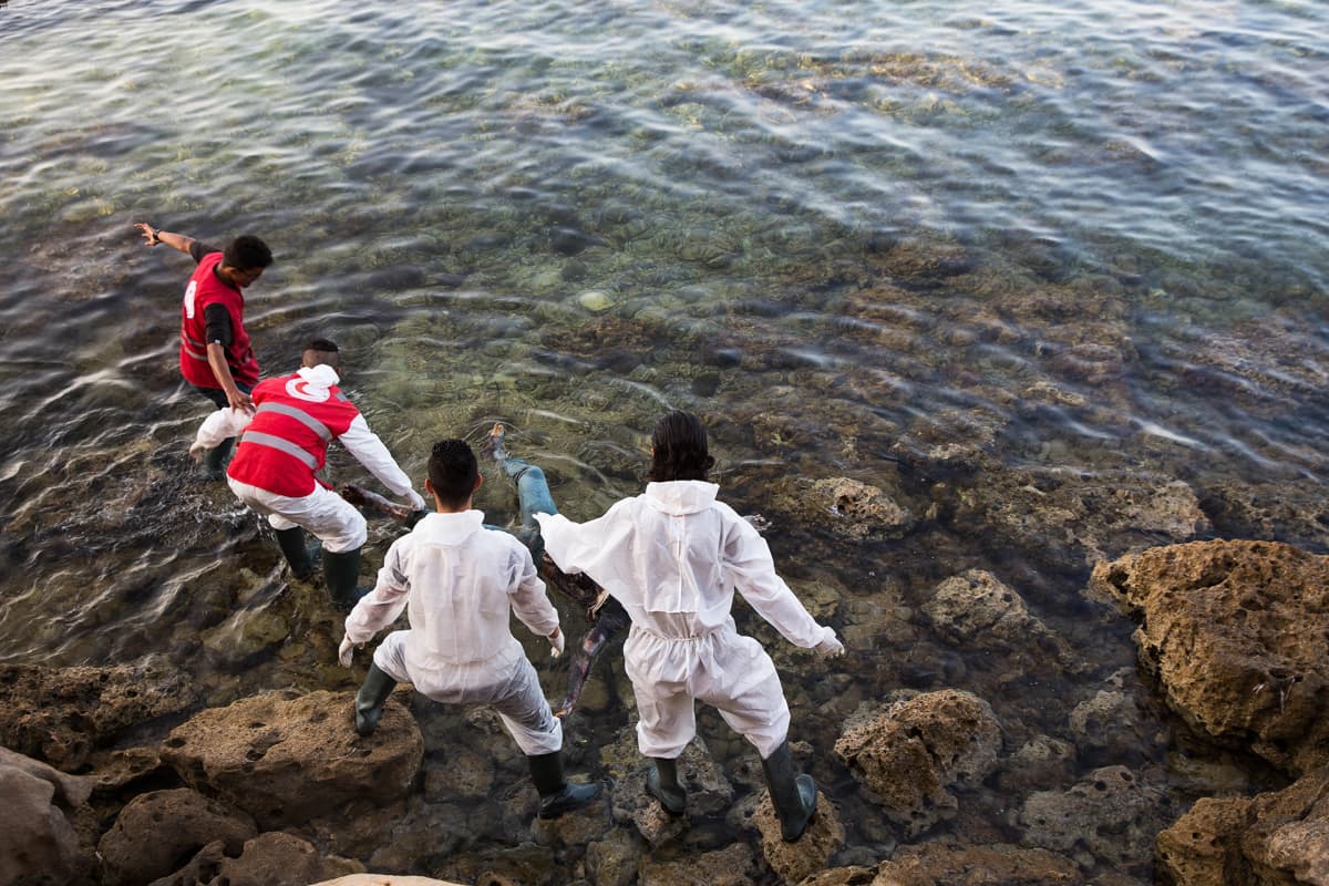 Libyan Punaisen puolikuun työntekijät etsivät rannoilta hukkuneiden pakolaisten ruumiita Tajourassa Tripolin itäpuolella heinäkuussa 2017.