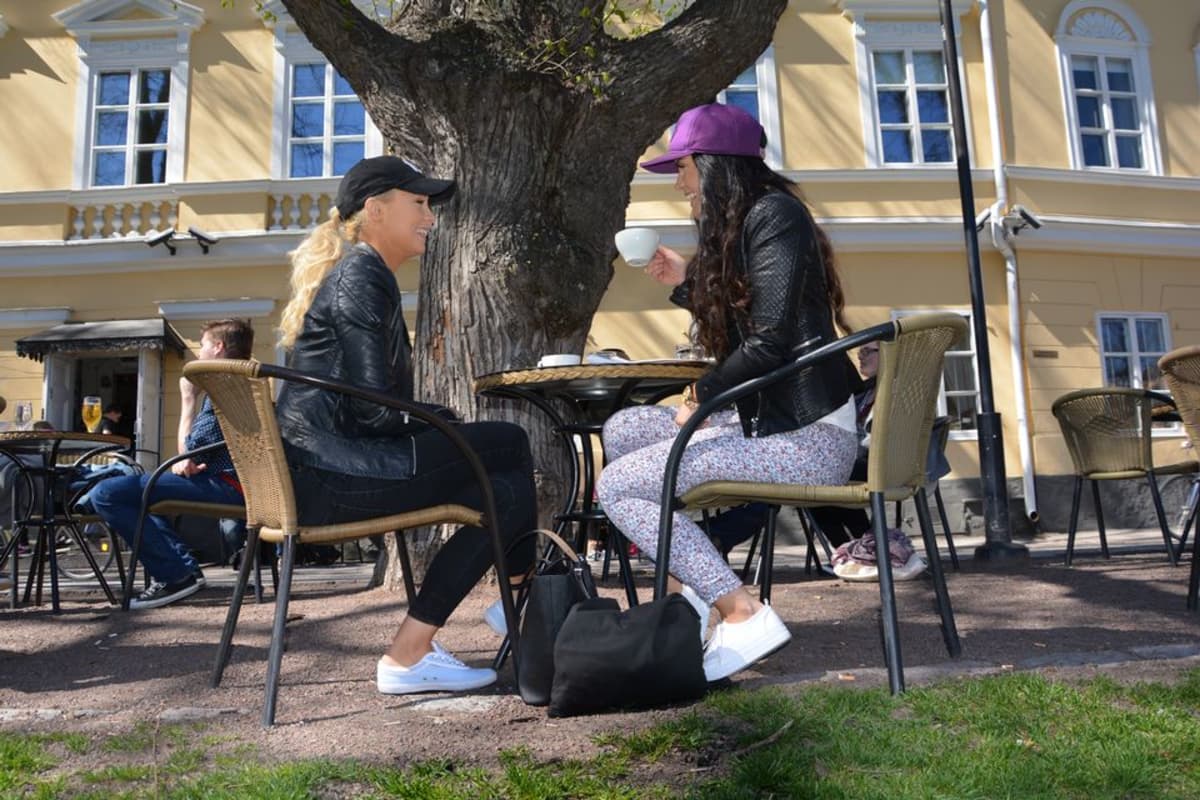 Nuoret naiset kahvilla Turun jokirannassa.