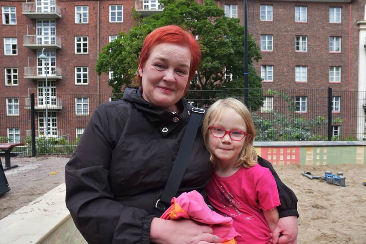 Virpi Kallas ja Annika Alarautalammi istuvat hiekkalaatikon reunalla.