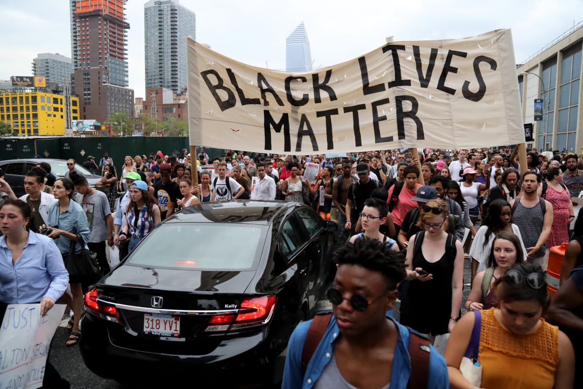 Mielenosoittajia kadulla, "Black lives matter" -kyltti