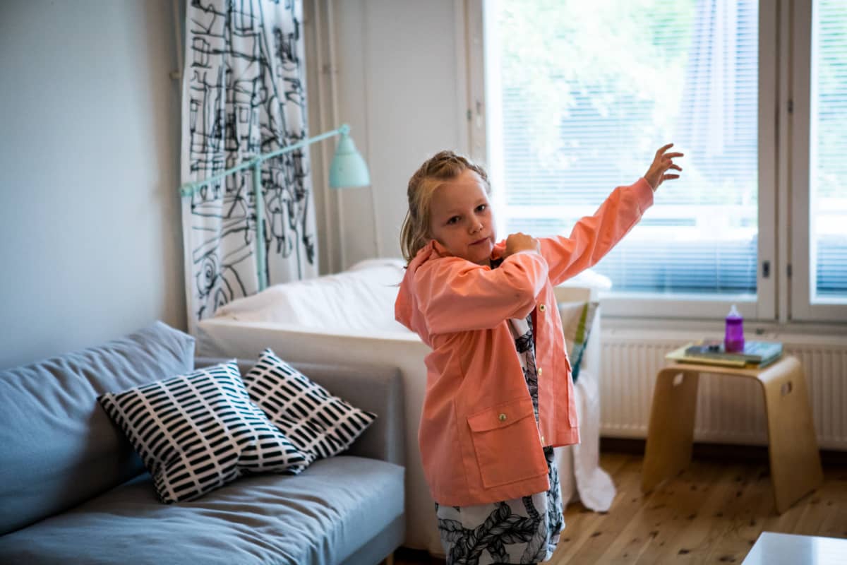 Matilda Salmi aloittaa koulun tänään. Kuvassa hän pukee päälleen kotona.