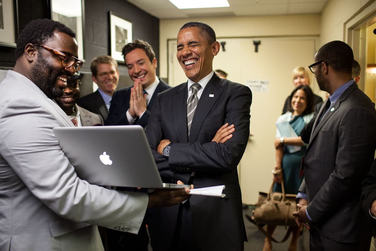Obama nauraa jollekin mitä hän on nähnyt tietokoneen ruudulla.