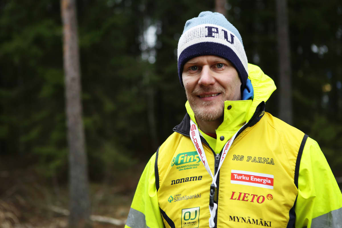 Suunnistaja poseeraa kameralle metsässä.