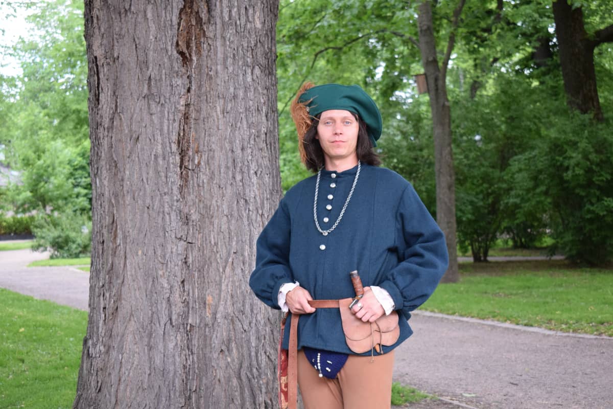 Markkinanäyttelijä keskiaikaisen kirjurin asussa.