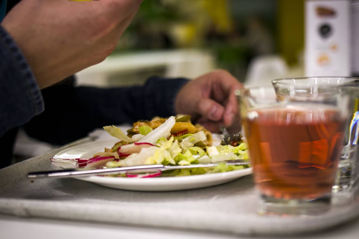 Opiskelija syö lounasta yliopiston ravintolassa.