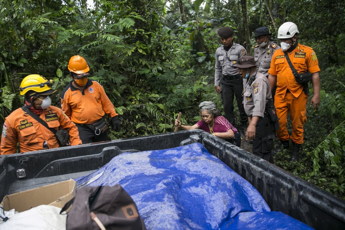 Indonesian viranomaiset evakuoimassa paikallista naista