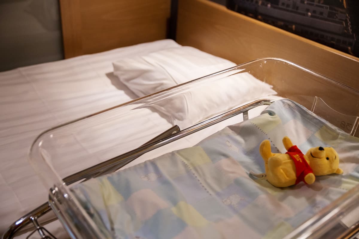 Naistenklinikkalla sänky ja vauvan sänky jossa nalle.