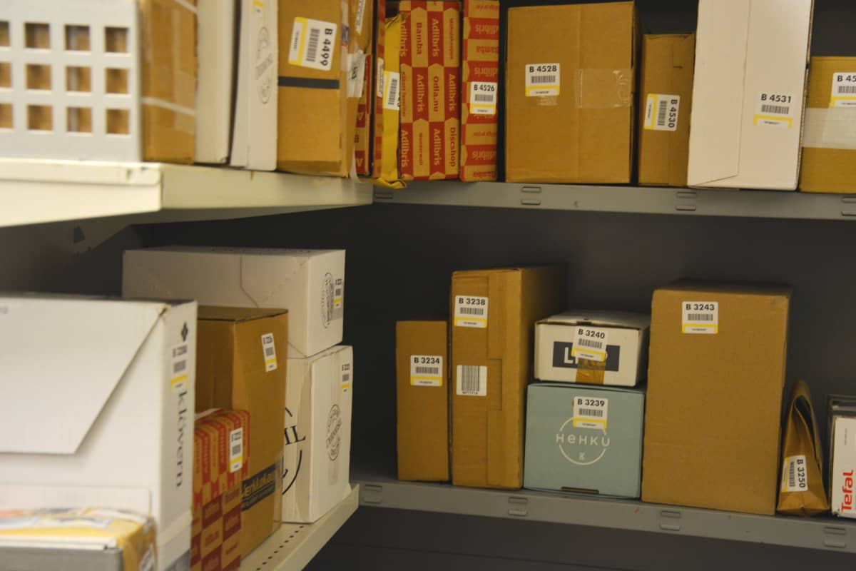 Postin paketteja hyllyllä.