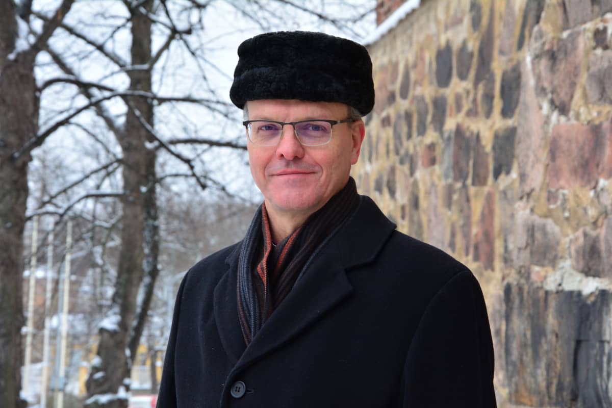 Tapio Luoma framför domkyrkans mur i vinterlandskap.