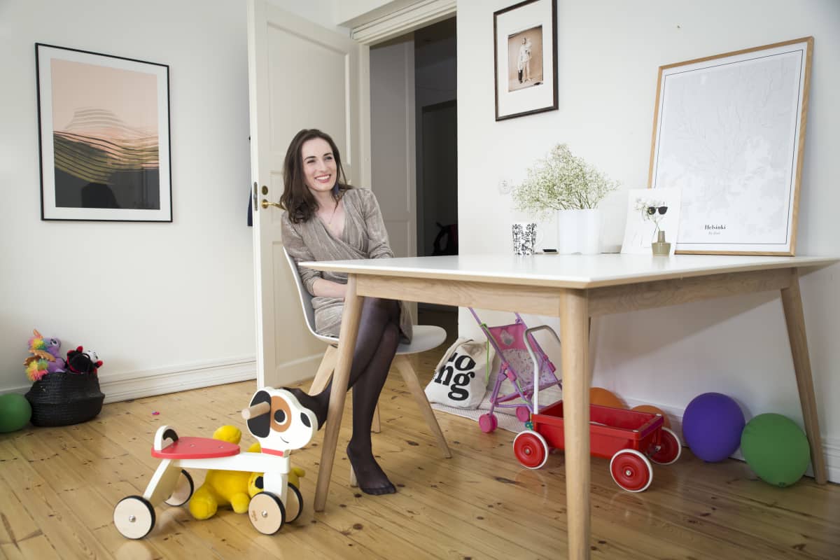 Elina Siira istuu olohuoneen pöydän ääressä