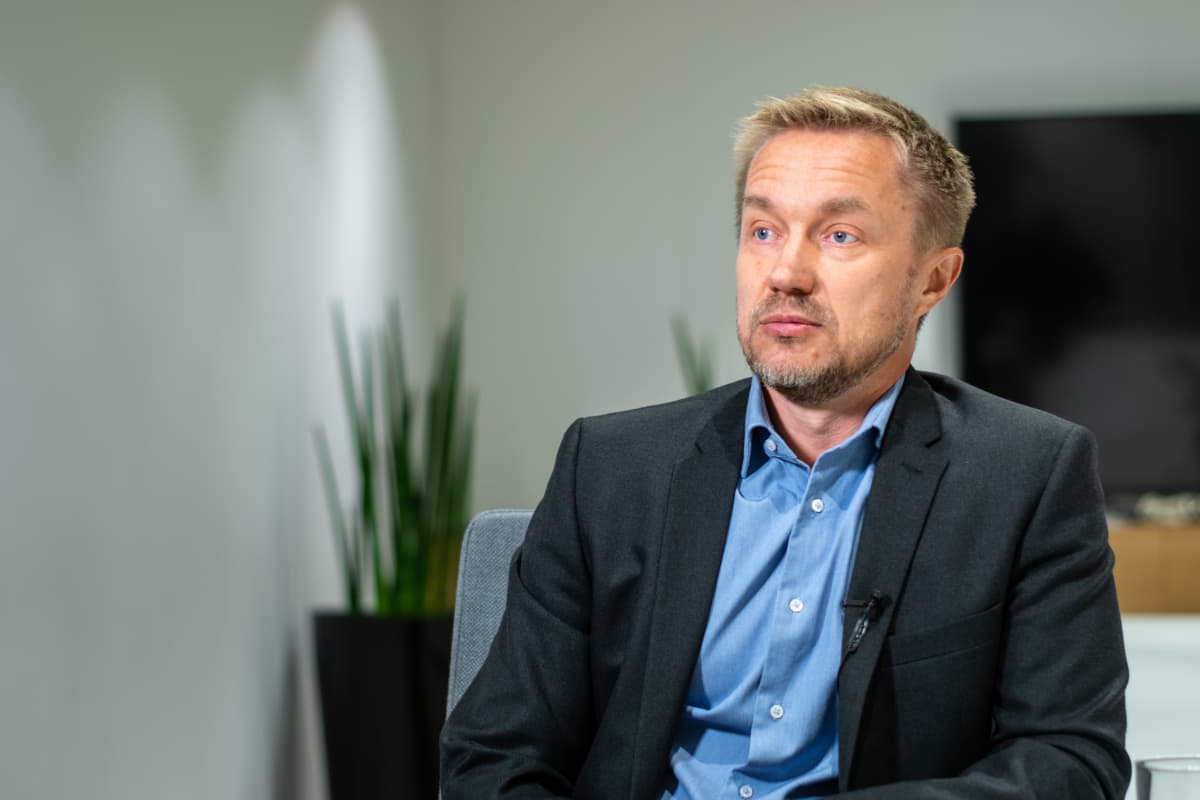 Direktör iklädd kavaj och kragskjorta sitter i ett mötesrum och blir intervjuad.