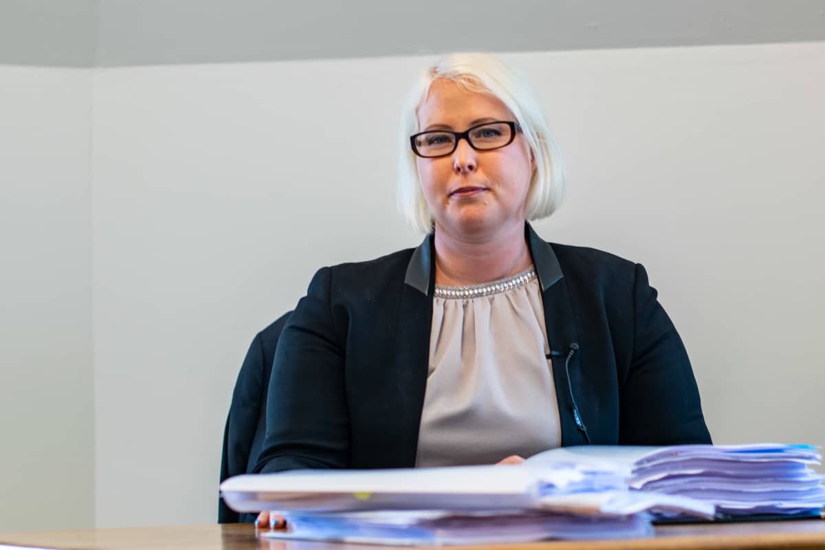 Porträttbild av kvinnlig advokat med blont hår och glasögon med mörka bågar.