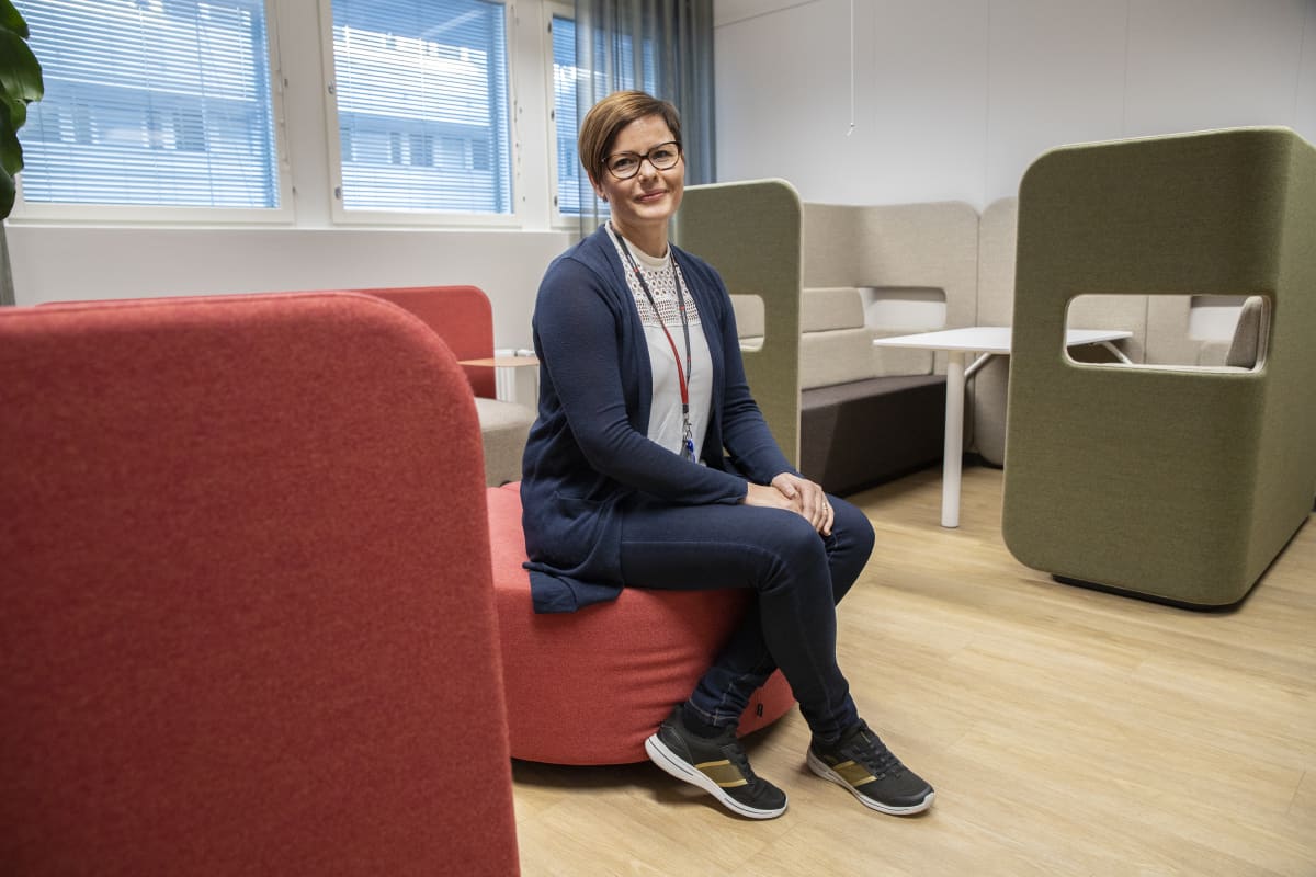 Katja Eskelinen Monetran toimiston aulatilassa sijaitsevilla sohvamoduuleilla