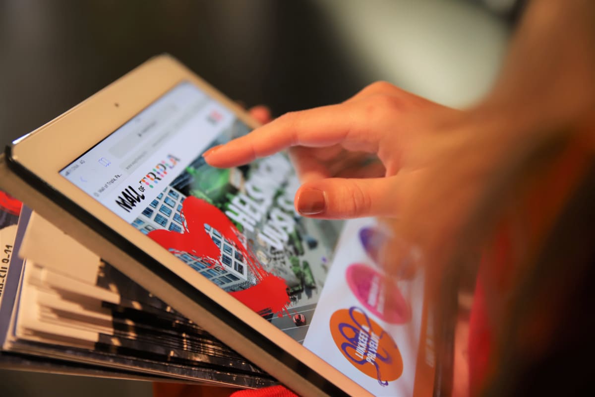 Lakattu sormenkynsi osoittaa tekstiä tabletilta