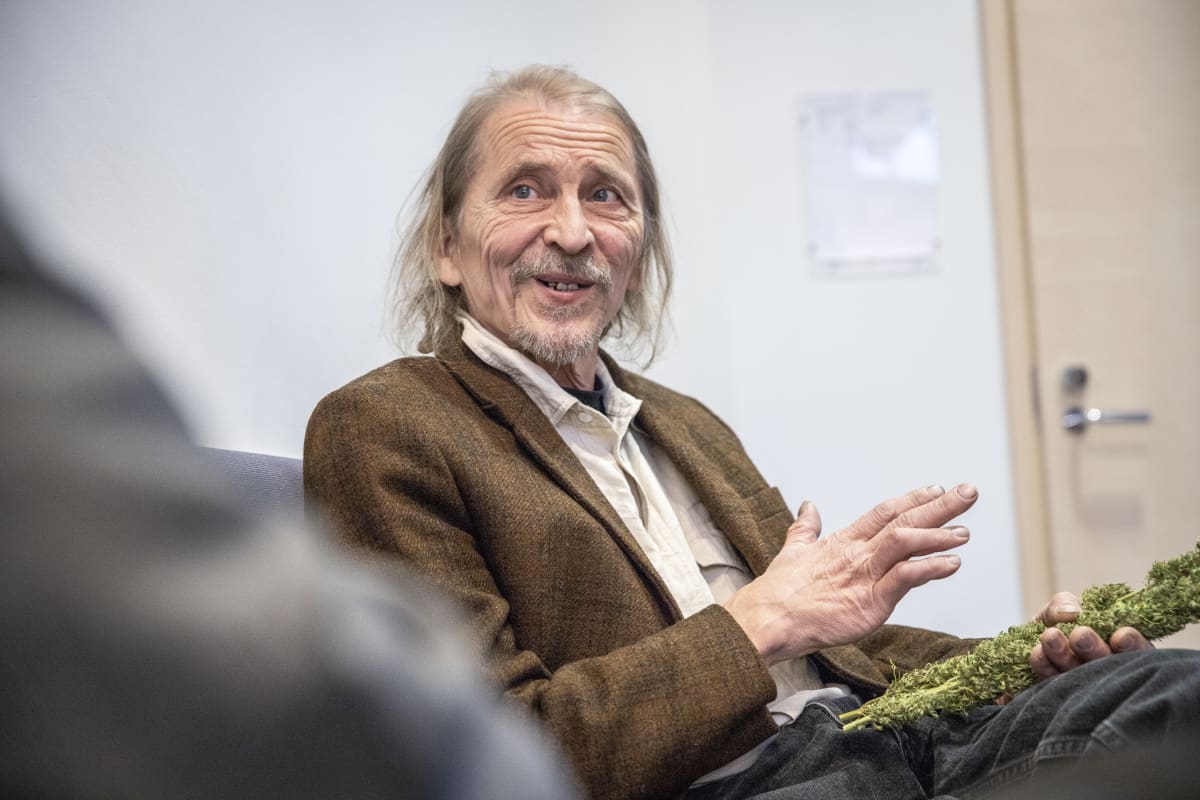 Hannu Hyvönen pitää kannabiskasvia kädessään käräjäoikeusistunnossa.
