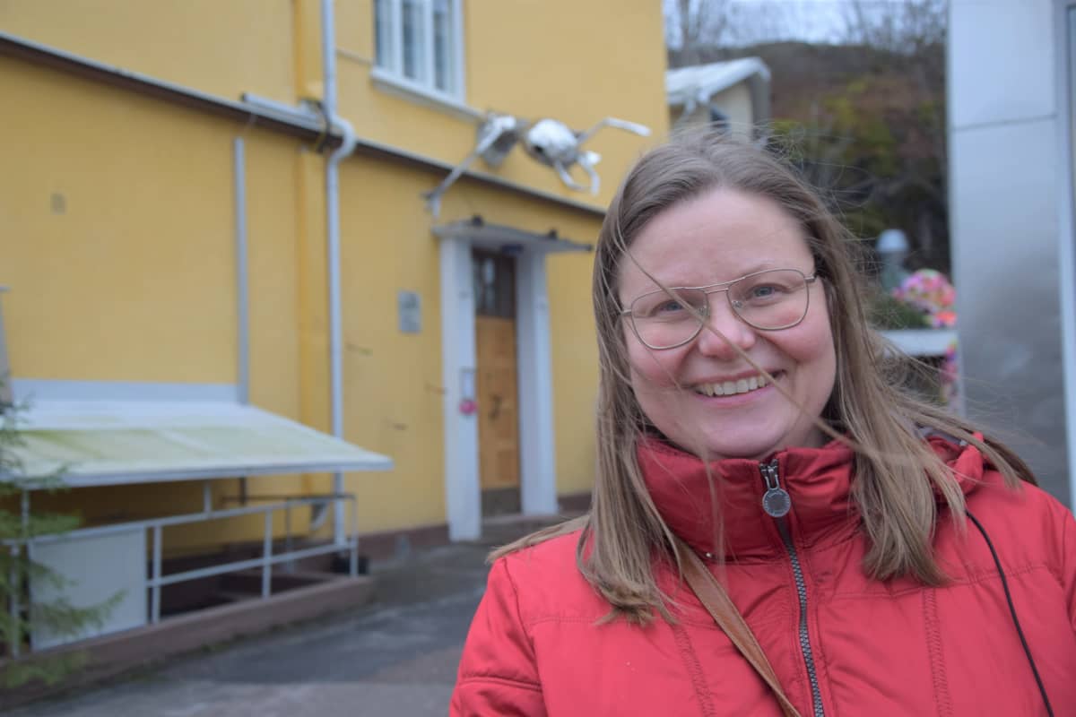 Nainen hymyilee kameralle.