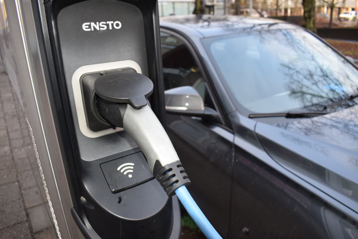 Ladattavan hybridin pistoke kiinni latausasemassa.