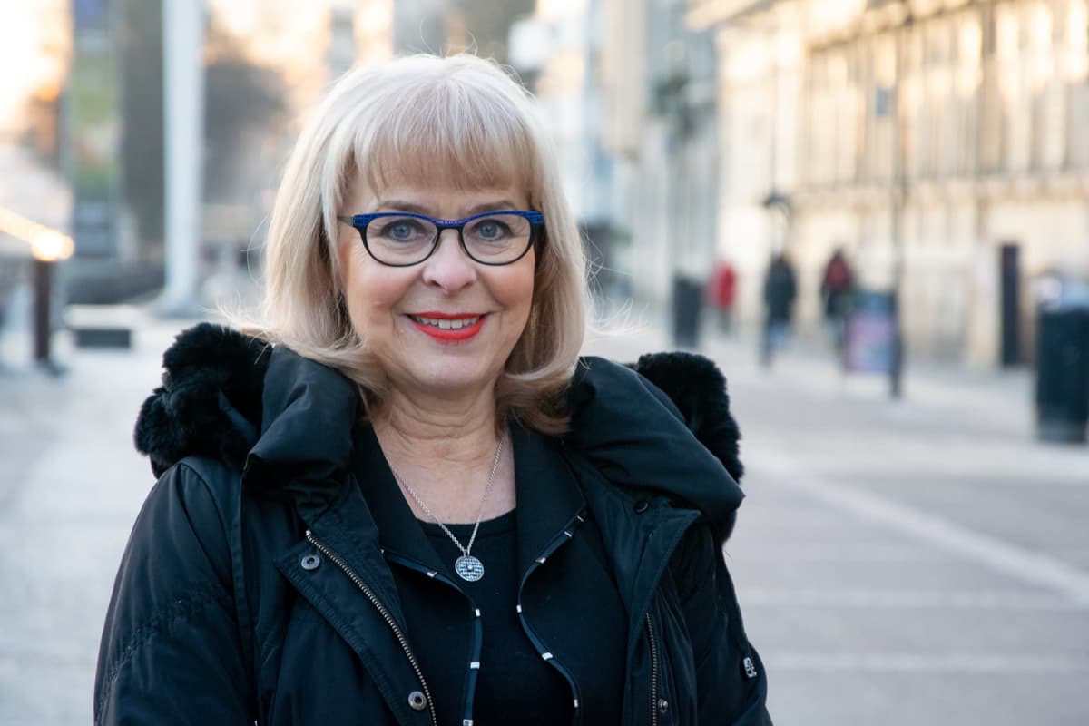 Nainen seisoo Turun Aurajoen rannassa.