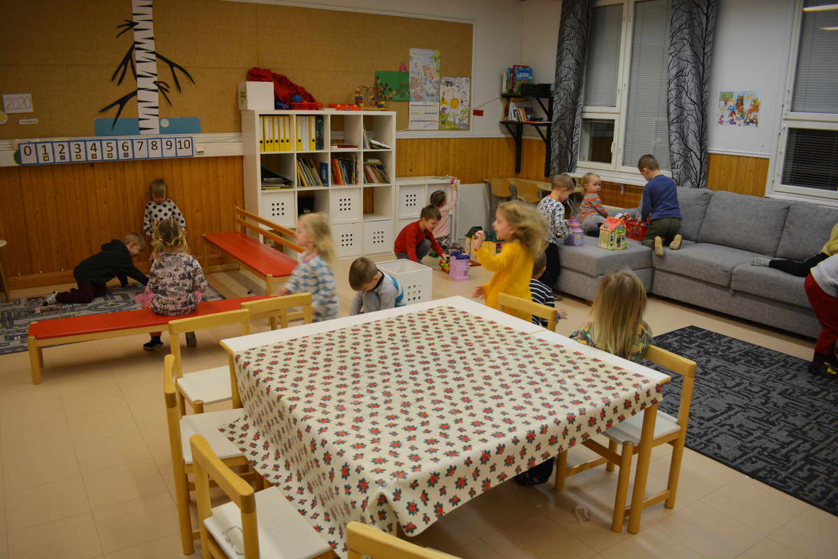 Päiväkotilapset leikkivät koululuokassa.