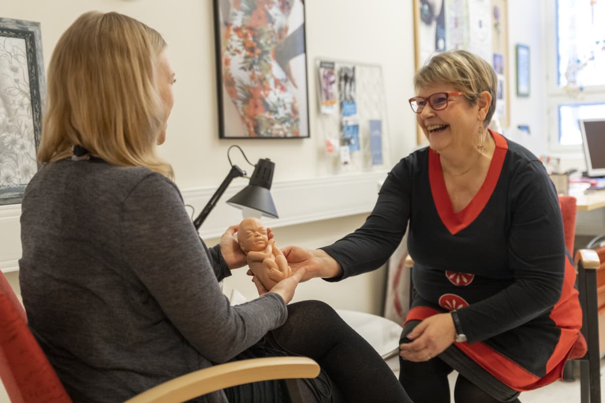 Päihde- ja sosiaalityöntekijä Anne Pitkänen ojentaa Hanna Hyytiäiselle tämän sikiötä vastaavan nuken.