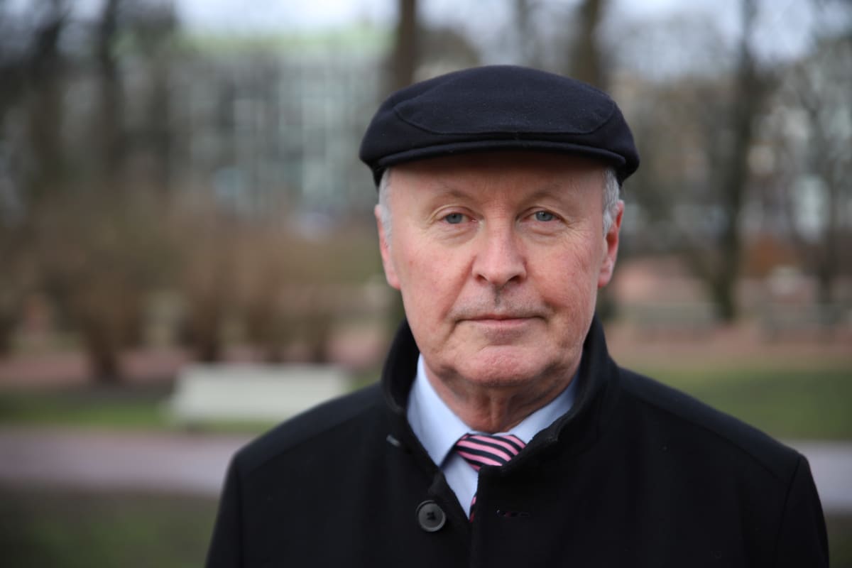 Mies katsoo kameraa kohti.