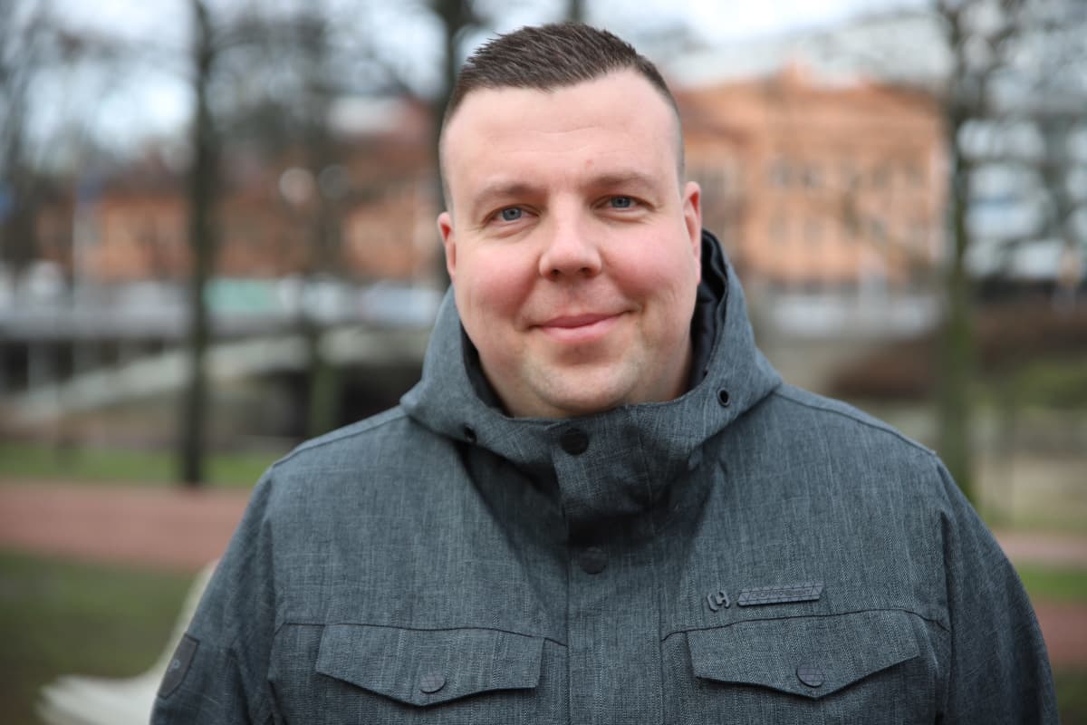 Mies katsoo kameraa kohti.
