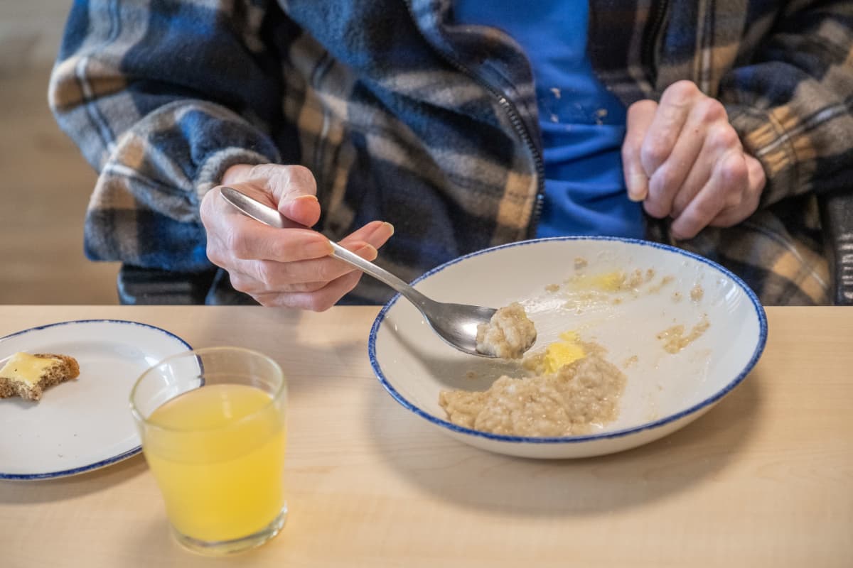 Vanhus ruokailee aamiaista.