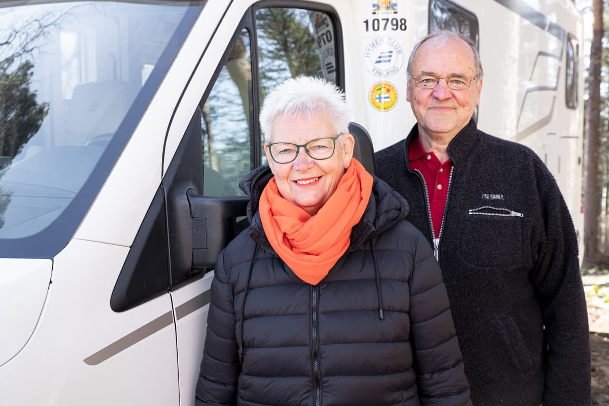 Pentti ja Pirkko Äijö poseeraavat matkailuautonsa vieressä.