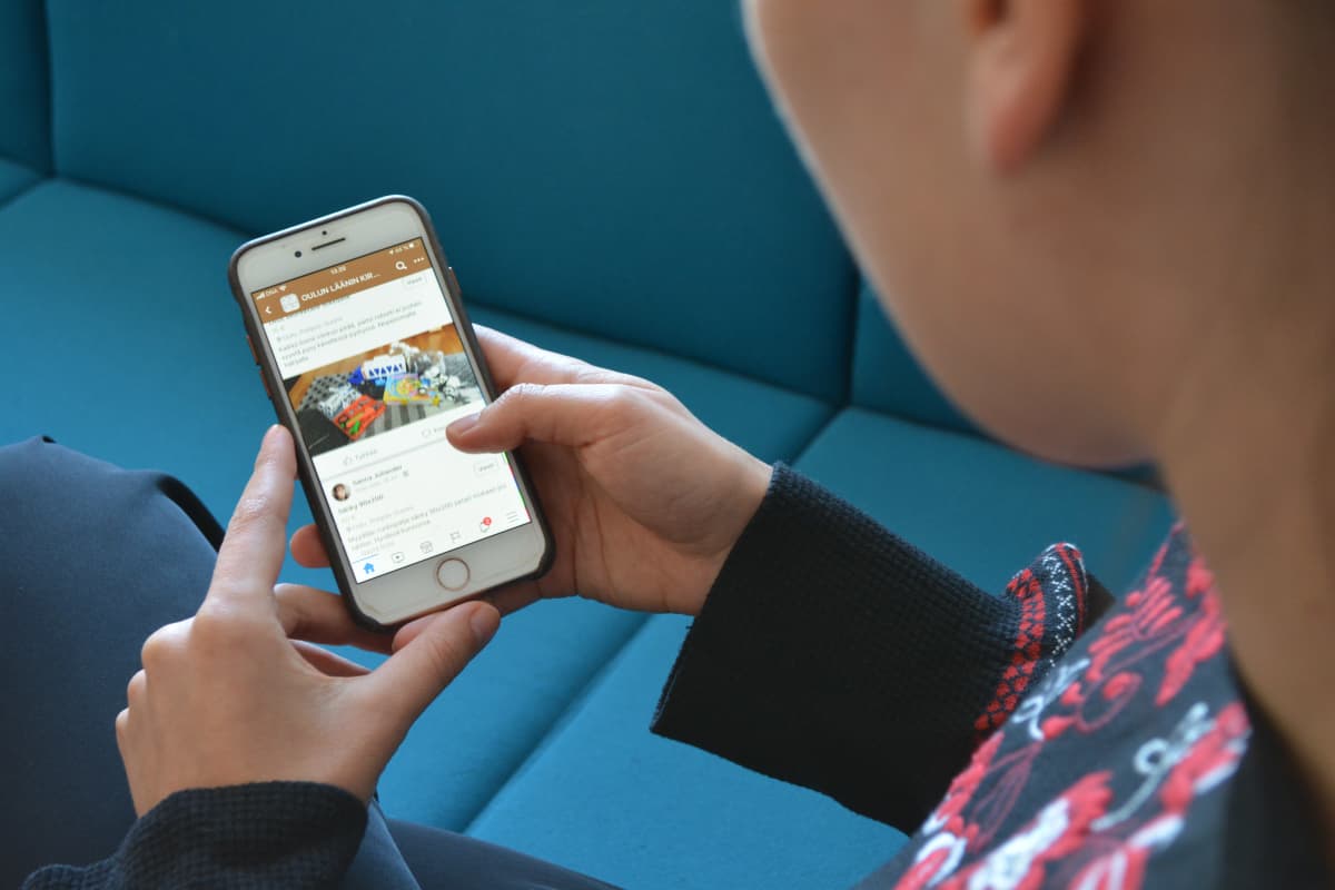 Henkilö selaa älypuhelimesta nettikirpputoria.