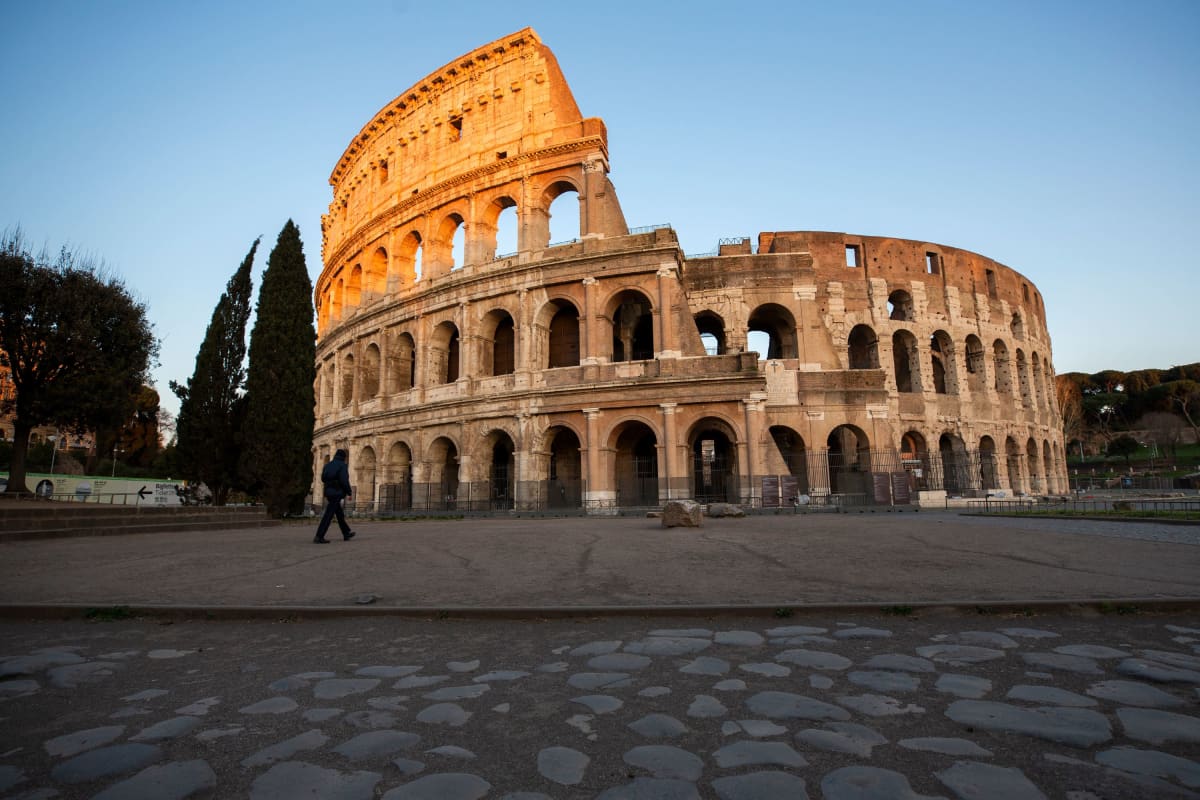 Mies kävelyllä Colosseumin ohitse Roomassa, Italiassa 23. maaliskuuta 2020.