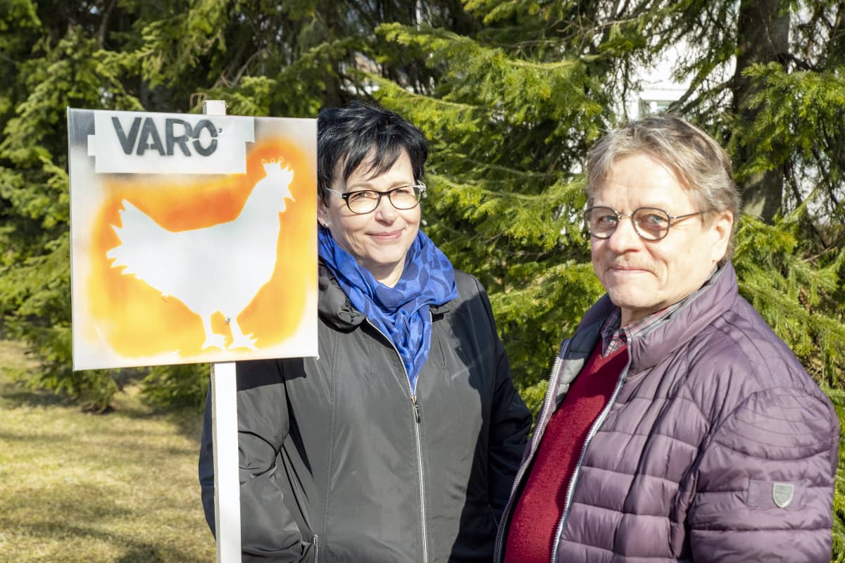Heikki ja Leena kivimäki ja varoitus kanasta -liikennemerkki.