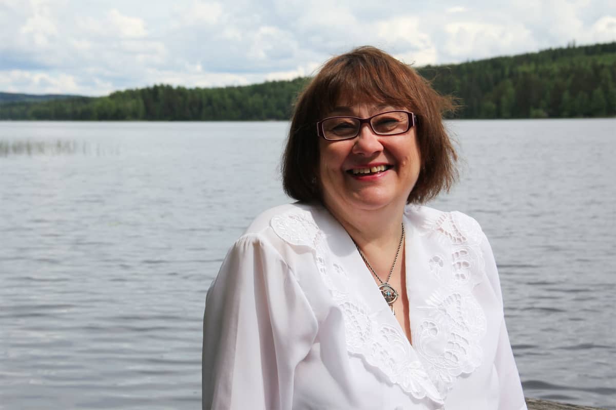 Liisa Arola-Lamminmäki hymyilee kameralle.