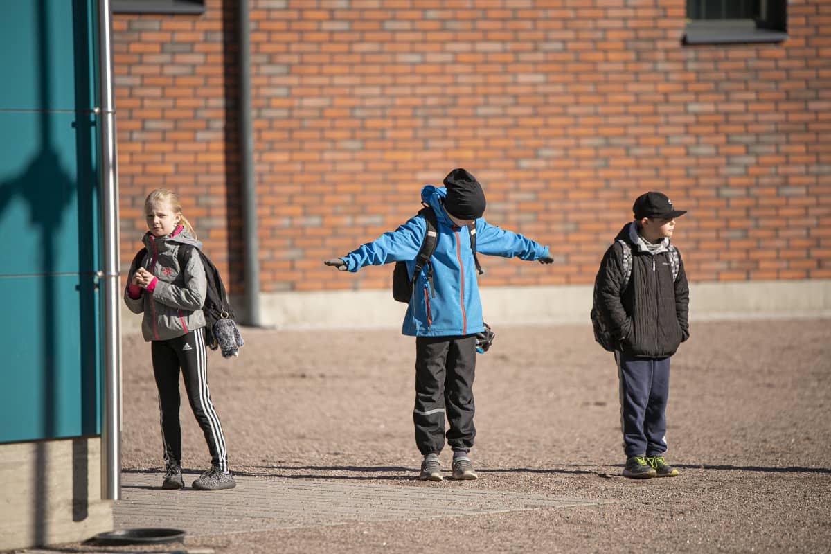 Oppilas varmisti, että onhan opettajan aiemmin ohjeistama turvaväli varmasti riittävä. Kouluun päästettiin sisälle kerrallaan muutama oppilas.