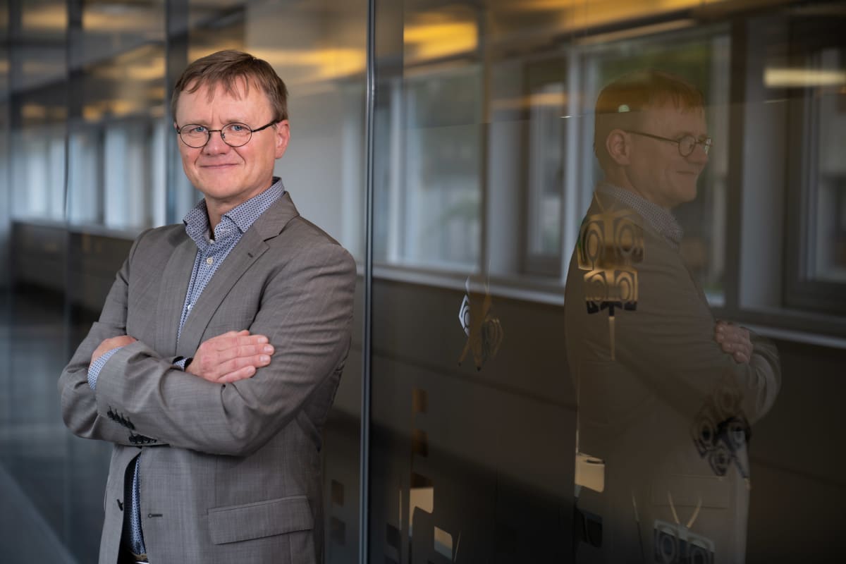 Timo Koivurova seisoo kädet puuskassa Ylen käytävällä.