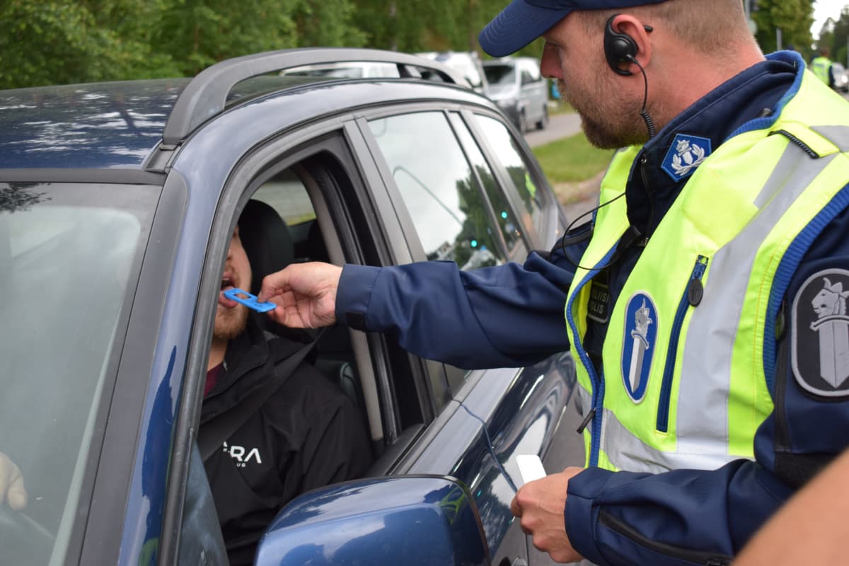 Poliisi tekee huumepikatestiä auton kuljettajalle.