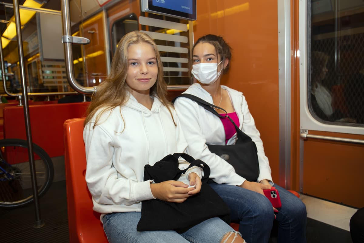 Kaksi nuorta naista metrossa.