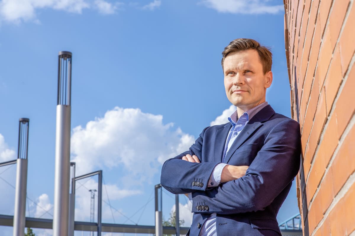 Mikael Palola nojaa tiiliseinään.