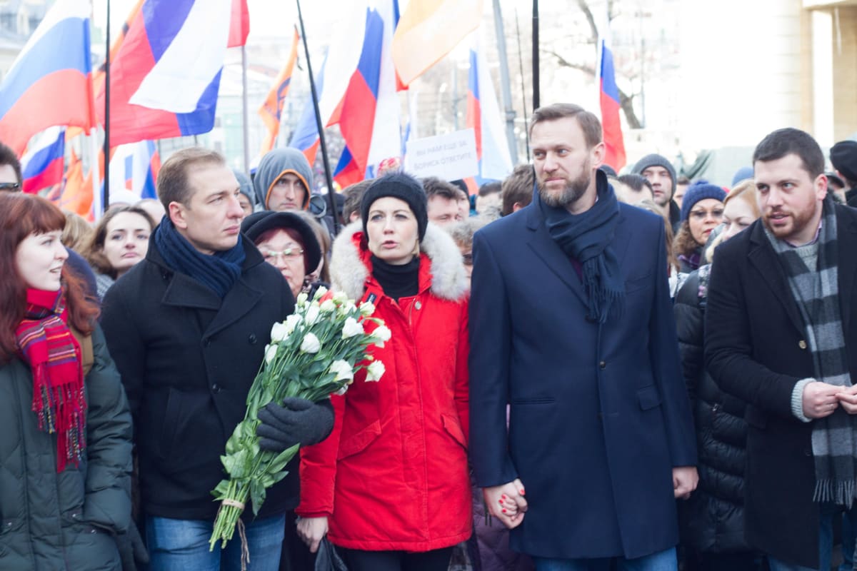 Venäjän oppositio marssilla. Kuvan oikeassa reunassa ovat Julija Navalnaja, Aleksi Navalnyi, Leonid Volkov. Julija Navalnajalla on punainen takki, Navalnyillä tummanharmaa päällystakki ja Volkovilla musta takki. Taustalla kannetaan Venäjän lippuja.