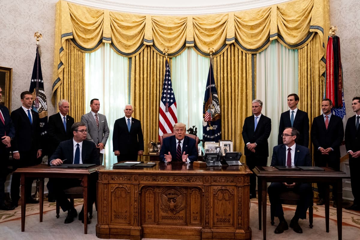 Donald Trump työpöytänsä takana, vasemmalla puolellaan Serbian Aleksandar Vucic ja Kosovon Avdullah Hoti pienempien pöytien takana