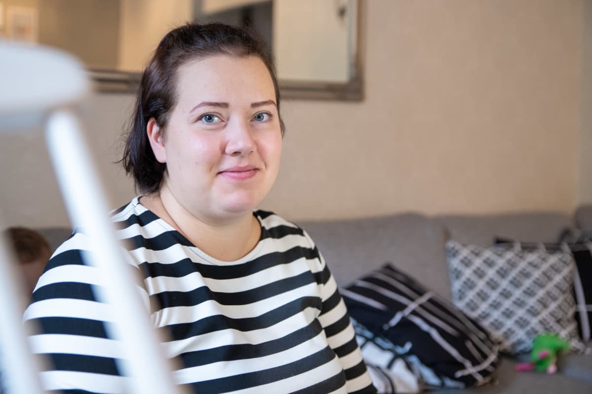 Sonja Kyrönlahti istuu olohuoneen sohvalla.