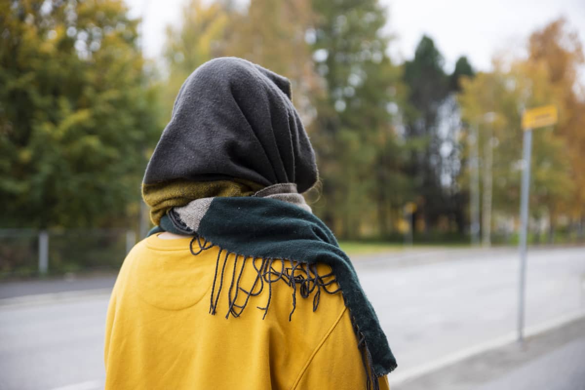 Tunnistamaton nainen kuvattuna takaapäin.
