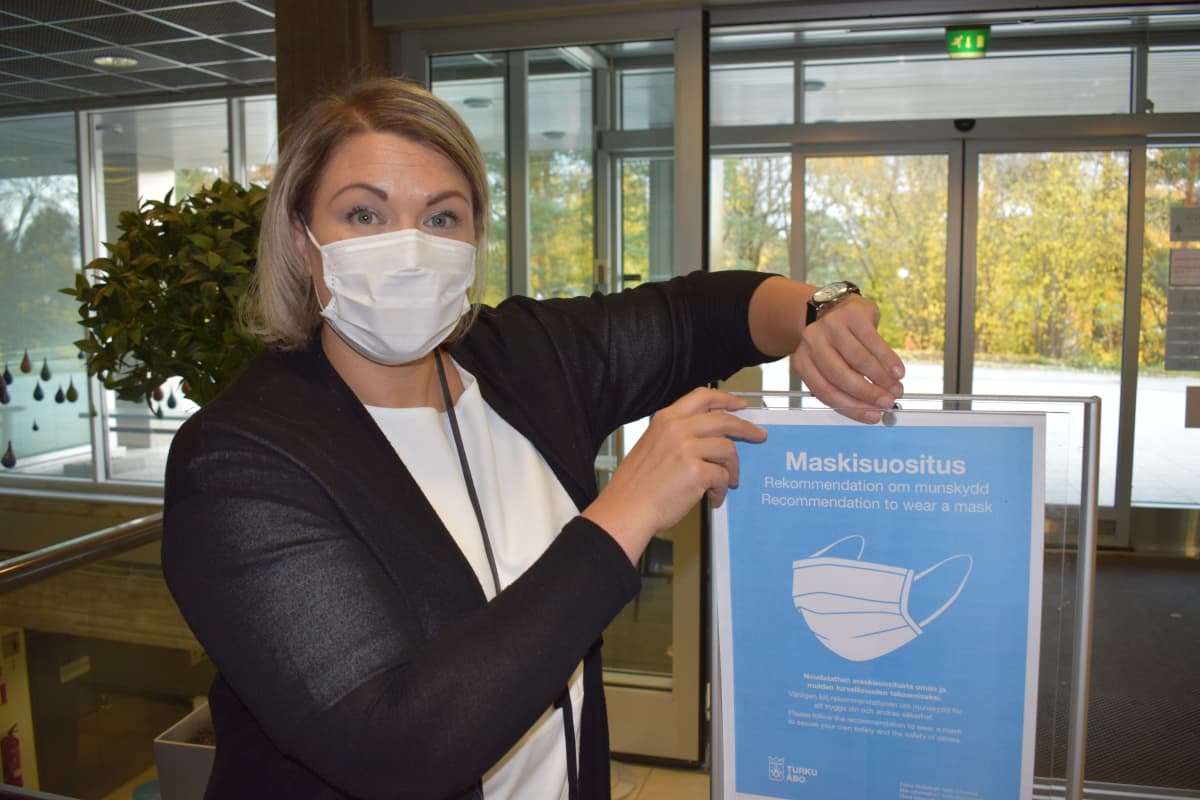 Turun kaupungin uimalaitosten päällikkö Eeva Haapanen näyttää kasvimaskisuosituskylttiä.