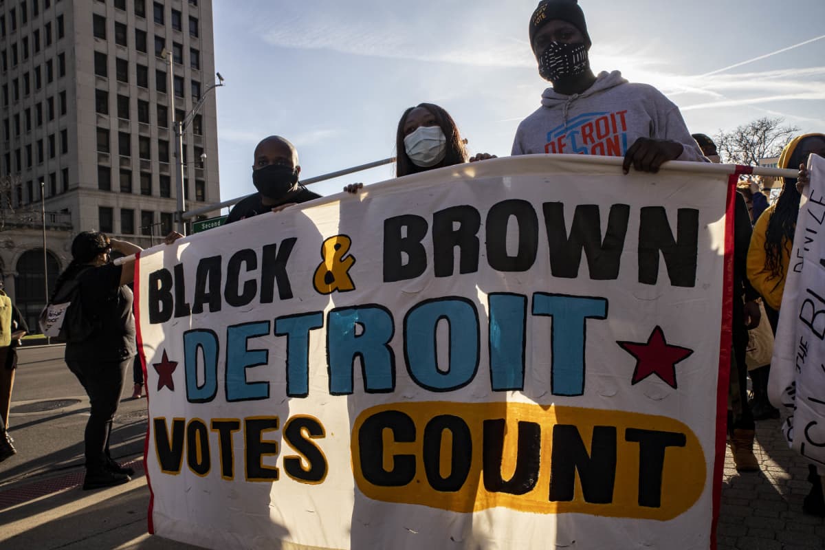 Mienosoittajat kantavat kylttiä Detroitissa. Bannerissa lukee englanniksi: Black&Brown Detroit votes count.