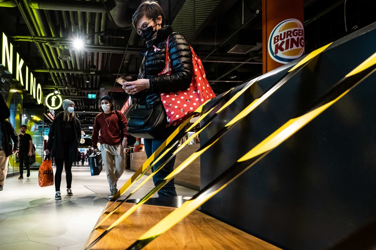 Kauppakeskuksessa ihmisiä suojautuneena kasvomaskeihin.