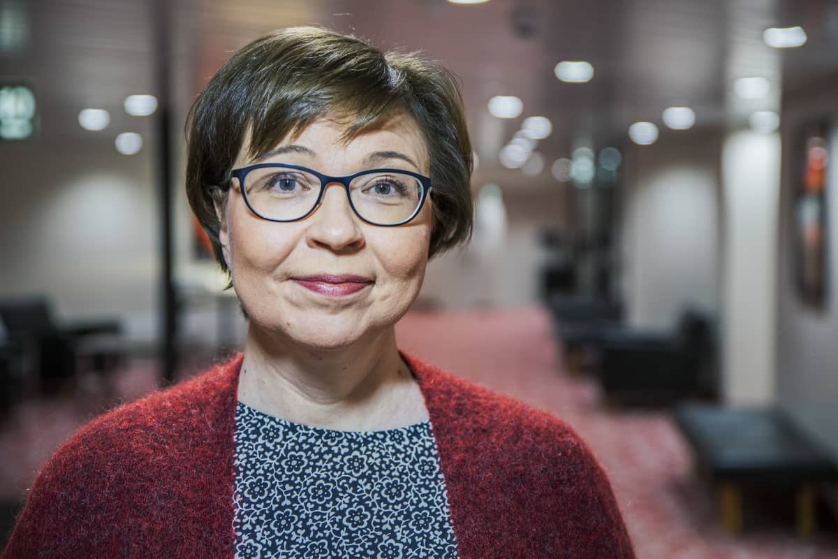 Pirjo Peräaho poseeraa kameralle hotellin käytävällä.