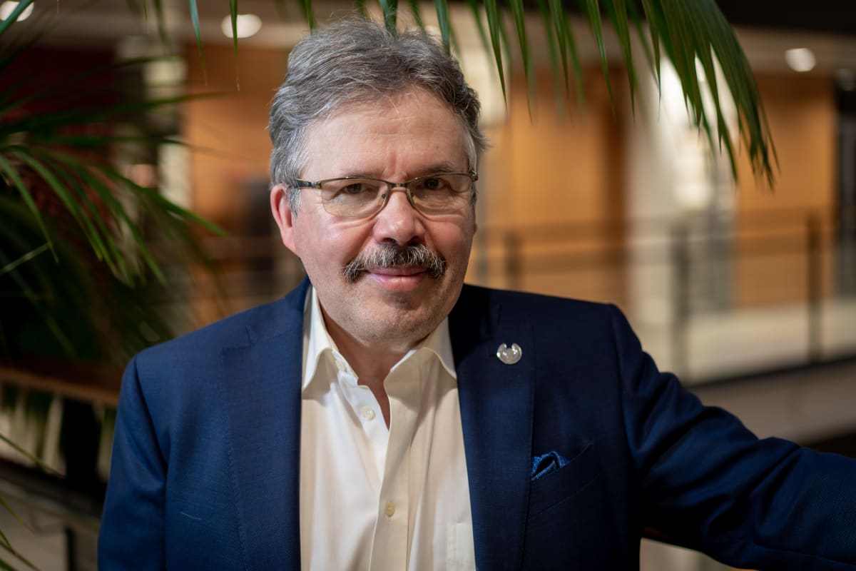 Tutkimusjohtaja, professori Mikael Knip nojaa kaiteeseen Biomedicumin aulassa.